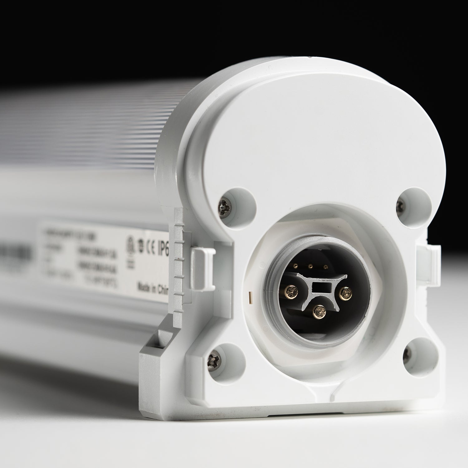 A close-up of the power source attachment of a Faven Chroma LED under canopy light on a white surface in front of a black background.