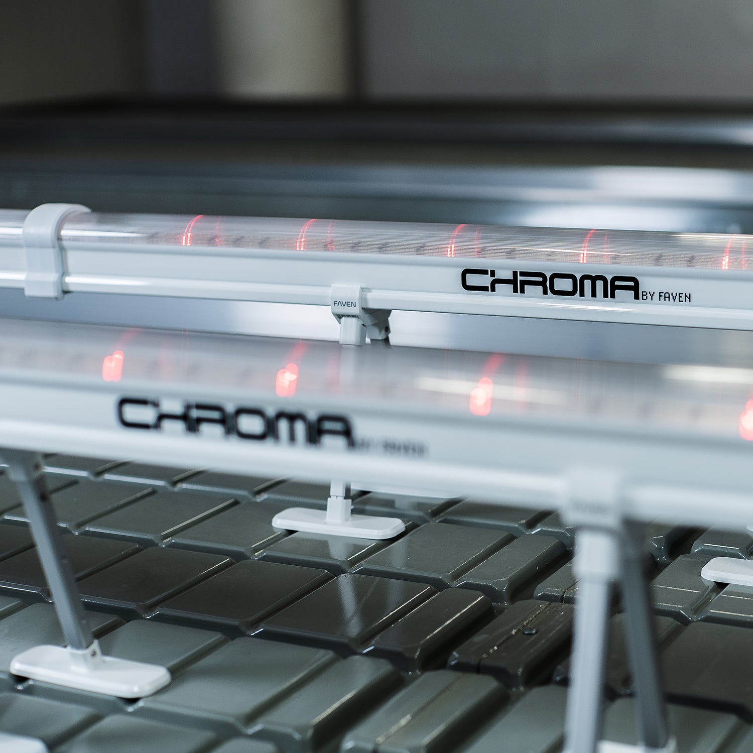 Close-up of Chroma by Faven UCL lights on a metal surface. In this image the light in the foreground i blurry and the light in the background is sharp.