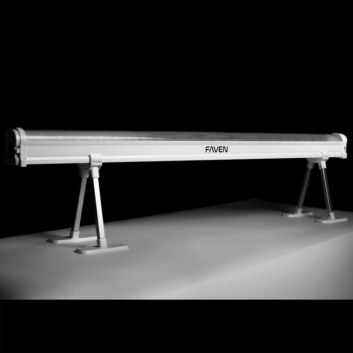 Angled side view of a Faven under canopy light shown here with its stands on a white table in front of a black background.